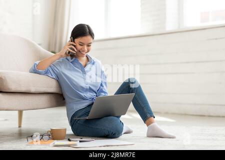 Koreanische Geschäftsfrau, die von zu Hause aus arbeitet und einen Anruf hat Stockfoto