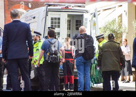 London, Großbritannien. 17. Mai 2022. Die Polizei durchsucht und verhaftete einen Protestierenden, der sich auf dem Balkon befand. Klimaaktivisten störten den Africa Energies Summit im May Fair Hotel in Mayfair und forderten die Finanzierung erneuerbarer Energien, den Schuldenerlass, ein Ende des Ölkolonialismus und Gerechtigkeit für Afrika. Mehrere Aktivisten sperrten sich innerhalb des Veranstaltungsortes und auf dem Balkon ein, während andere draußen Transparente hingen und das Gebäude mit gefälschtem Öl besprühten. Kredit: Vuk Valcic/Alamy Live Nachrichten Stockfoto