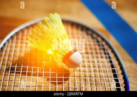 Gelber Federball für Badminton liegt auf Schlägersaiten. Hintergrund. Nahaufnahme. Stockfoto