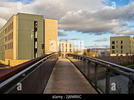 Blick über eine Fußgängerbrücke über den Leeds und Liverpool Canal in Richtung Sandygate Halls, Burnley College, UCLAN Stockfoto