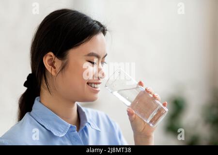 Seitenansicht der koreanischen Frau, die Wasser trinkt Stockfoto