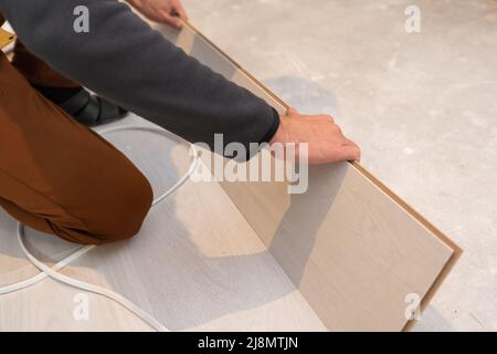 Längsverbindung. Die Reihenfolge der technologischen Methoden für die Verlegung und Montage von schwimmenden Bodenbelägen - Laminat Stockfoto