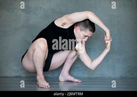 Nicht binär, sie/sie in Squat-Position Stockfoto