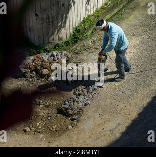 8.. August 2020. Uttarakhand, Indien. Ein Bauarbeiter, der auf einer Straße in Indien zur Reparatur Hammerbohrer oder Presslufthammer betreibt. Stockfoto