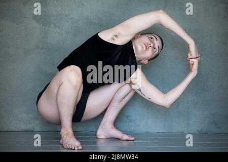 Nicht binär, sie/sie in Squat-Position Stockfoto