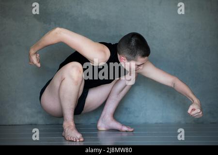 Nicht binär, sie/sie in Squat-Position Stockfoto