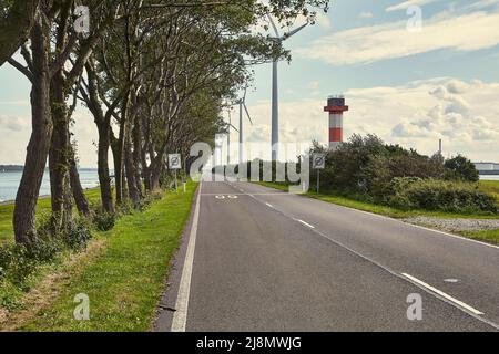 Straße auf einem schmalen Land am Wasser im Hafen von Rotterdam Stockfoto