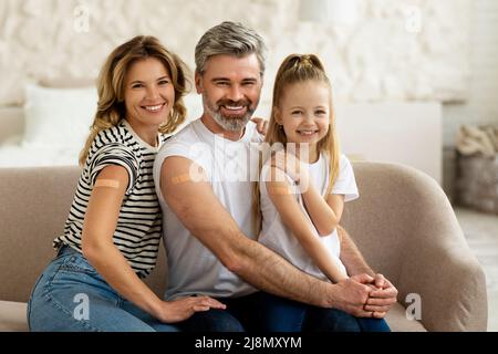 Familie Mit Kind Zeigt Geimpfte Arme Mit Gips Zu Hause Stockfoto