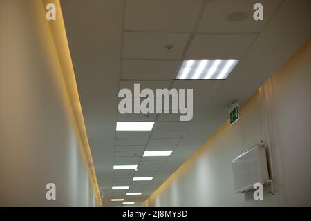 Lampen im Flur. Licht an der Decke. Details des Bürogebäudes. Leuchtstofflampen. Stockfoto