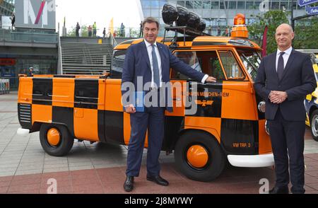 München, Deutschland. 17.. Mai 2022. Der bayerische Ministerpräsident Markus Söder (CSU) steht im Münchner Airport Center am Franz-Josef-Strauß-Flughafen München mit Jost Lammers (r), Vorsitzender der Geschäftsführung der Flughafen München GmbH, vor einem historischen Vorfeldfahrzeug. Quelle: Karl-Josef Hildenbrand/dpa/Alamy Live News Stockfoto