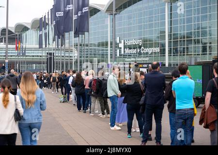 Hamburg, Deutschland. 17.. Mai 2022. Zahlreiche Besucher stehen vor dem Haupteingang der Messe und warten auf ihr Ticket oder ihren Eintritt. Das OMR Digital Festival in Hamburg startete am Dienstag mit großen Menschenmengen und langen Schlangen an den Eingängen. Quelle: Jonas Walzberg/dpa/Alamy Live News Stockfoto