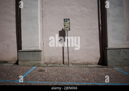 Altes Zeichen des kostenpflichtigen Parkens durch Zeit und Zeiger auf Parkschein in Italien. Parkplatz mit blauen Markierungen auf gepflasterter Straße und Zeiger Stockfoto