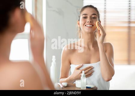 Glückliche Dame Mit Sponge Tun Gesichtshaut Routine Im Badezimmer Stockfoto