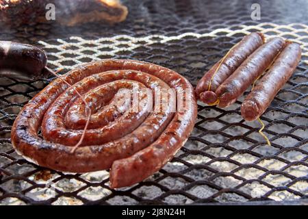 Nahaufnahme der Spule einer Grillwurst und Schweinewurst auf dem Grill. Typisch argentinisches Essen am Wochenende Stockfoto