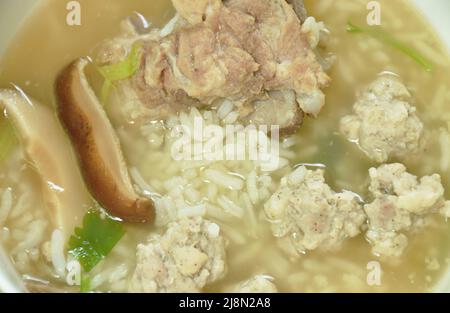 Gekochter Reis mit Schweinekotelett und heißer Knochensuppe auf der Schüssel Stockfoto