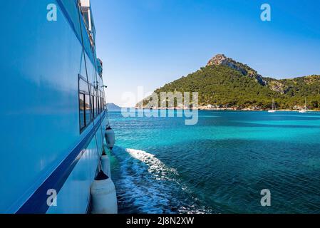 Zugeschnittenes Bild eines Passagierbootes, das sich an einer Klippe gegen den blauen Himmel auf dem Meer bewegt Stockfoto