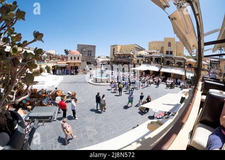 Ein Blick über den Hippokrates-Platz, die Altstadt von Rhodos, Rhodos, Griechenland. Das Bild zeigt Touristen und eine geführte Tour, die sich unter die berühmte Attraktion mischen Stockfoto