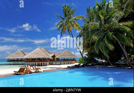 Menschen, die sich am Pool, auf der Insel Medhufushi, im Meemu-Atoll, auf den Malediven, im Indischen Ozean, Asien Stockfoto