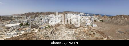 Die Hauptstadt und bevölkerungsreichste Stadt im Oman, Muscat, zeigt erstaunliche Orte, an denen seine weißen Gebäude von beeindruckenden Bergen umgeben sind Stockfoto