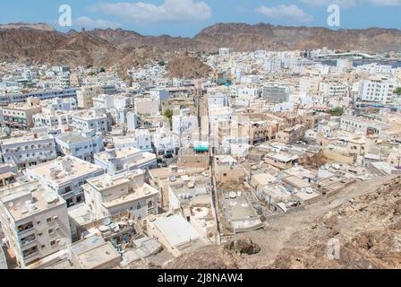 Die Hauptstadt und bevölkerungsreichste Stadt im Oman, Muscat, zeigt erstaunliche Orte, an denen seine weißen Gebäude von beeindruckenden Bergen umgeben sind Stockfoto