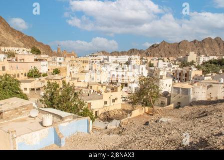 Die Hauptstadt und bevölkerungsreichste Stadt im Oman, Muscat, zeigt erstaunliche Orte, an denen seine weißen Gebäude von beeindruckenden Bergen umgeben sind Stockfoto