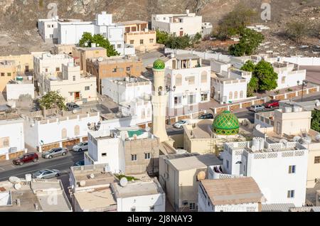 Die Hauptstadt und bevölkerungsreichste Stadt im Oman, Muscat, zeigt erstaunliche Orte, an denen seine weißen Gebäude von beeindruckenden Bergen umgeben sind Stockfoto