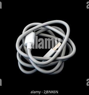Ein weißes usb-Kabel vom Typ C, das vor einem schwarzen Hintergrund isoliert ist. Stockfoto