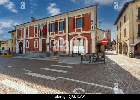 Caramagna Piemonte, Piemont, Italien - 10. Mai 2022: Das Rathaus auf dem Schlossplatz mit dem Uhrenturm im Hintergrund Stockfoto