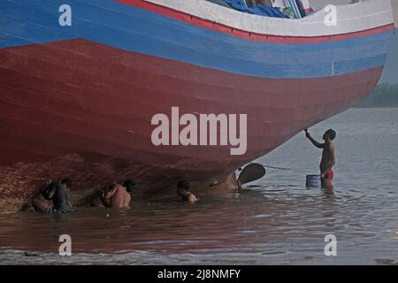 Kendari, Süd-Ost Sulawesi, Indonesien. 17.. Mai 2022. Fischer reinigen das Boot von Austern, die am Rumpf befestigt sind, bevor sie den Rumpf in Kendari lackieren, Dienstag, den 17. Mai 2022.Fischer in Kendari nutzen die ungünstige Wetterlage, um zum Meer zu fahren, indem sie ihr Fischerboot reparieren und warten, Dienstag, den 17. Mai 2022. (Bild: © Andry Denisah/ZUMA Press Wire) Stockfoto