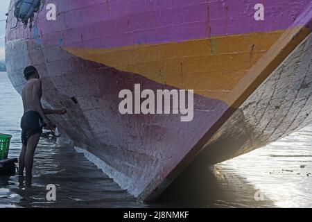 Kendari, Süd-Ost Sulawesi, Indonesien. 17.. Mai 2022. Fischer reinigen das Boot von Austern, die am Rumpf befestigt sind, bevor sie den Rumpf in Kendari lackieren, Dienstag, den 17. Mai 2022.Fischer in Kendari nutzen die ungünstige Wetterlage, um zum Meer zu fahren, indem sie ihr Fischerboot reparieren und warten, Dienstag, den 17. Mai 2022. (Bild: © Andry Denisah/ZUMA Press Wire) Stockfoto