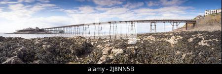 Birnbeck Pier in Weston-super-Mare, England, bei Ebbe. Jetzt nicht mehr genutzt, verbindet es das Festland mit der Insel Birnbeck und ist Grade II gelistet. Stockfoto