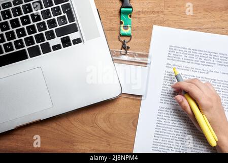 Ansicht von oben auf einen Schreibtisch, ein leerer Personalausweis mit einer Trageschlaufe aus Sonnenblumen, Symbol für Menschen mit unsichtbaren oder versteckten Behinderungen; eine unbekannte Person Studie Stockfoto