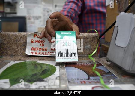 New York, USA. 17.. Mai 2022. Ein Ladenbesitzer hält eine Packung Menthol Marlboro Zigaretten im Stadtteil Queens von New York City, NY, 17. Mai 2022. Die FDA gab bekannt, dass sie beabsichtigt, Menthol-Zigaretten aufgrund höherer Raten von rauchbedingten Krankheiten und Todesfällen in afroamerikanischen Gemeinden, in denen sie stark beworben werden, sowie aromatisierte Zigarren, die bei jüngeren Rauchern beliebt sind, zu verbieten; die Menthol-Chemikalie, die Zigaretten hinzugefügt wird, reduziert Rachenreizungen im Zusammenhang mit dem Rauchen. (Foto von Anthony Behar/Sipa USA) Quelle: SIPA USA/Alamy Live News Stockfoto