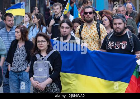 Sofia, Bulgarien - 09. Mai 2022: Zwei Männer halten eine große ukrainische Flagge vor sich und gehen in einer Menschenmenge Stockfoto