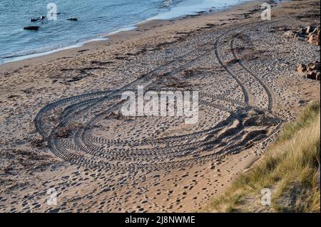Traktorreifen an einem Sandstrand in Irland Stockfoto