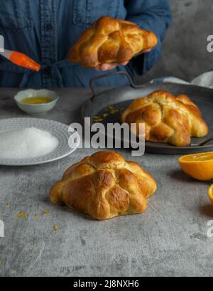 Frau, die Pan de muertos Brot der Toten für den mexikanischen Tag der Toten bereitet. Stockfoto