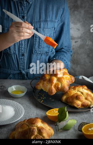 Frau, die Pan de muertos Brot der Toten für den mexikanischen Tag der Toten bereitet. Stockfoto