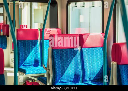 Leere Passagiersitze in Nahaufnahme des modernen Zuges. Stadttramsportkonzept Stockfoto