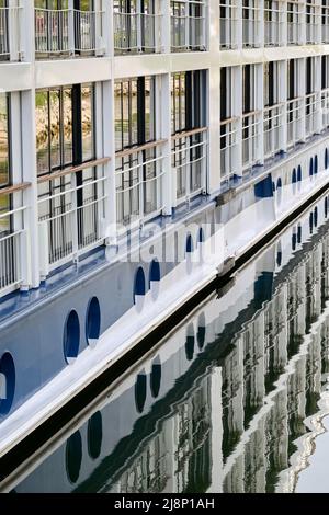 Breisach, Deutschland - April 2022: Seitenansicht eines Flusskreuzfahrtschiffes mit Spiegelung in Fenstern und Wasser Stockfoto