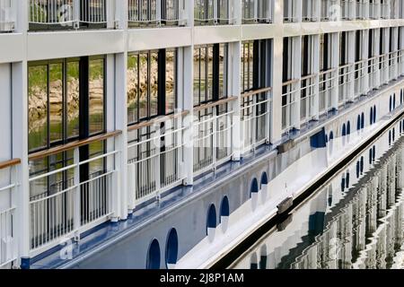 Breisach, Deutschland - April 2022: Seitenansicht eines Flusskreuzfahrtschiffes mit Spiegelung in Fenstern und Wasser Stockfoto