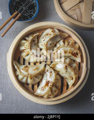 Gyoza japanische koreanische Knödel auf grauem Teller auf dem Tisch. Draufsicht Stockfoto