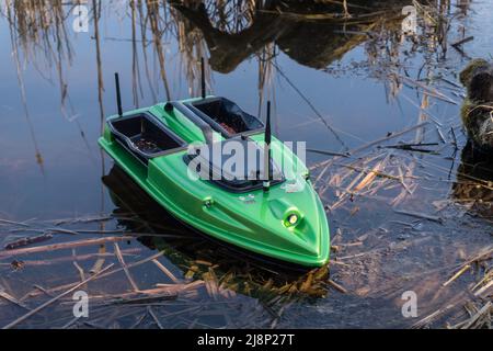 Bait Boot auf dem Wasser. Drahtlose Fernbedienung grünes Fischfutter, Fischsucher Boot. Stockfoto