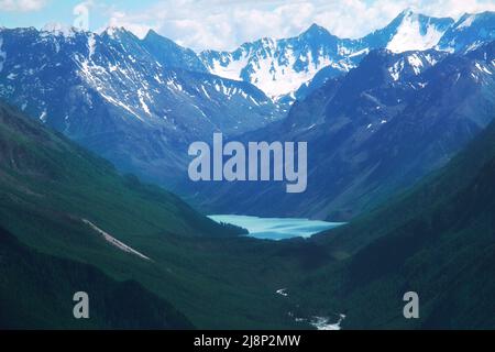 Alpine schöne blaue See in Altai in einer Bergschlucht mit hohen Bergen mit schneebedeckten Gipfeln im Sommer Stockfoto