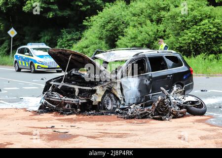 Gevelsberg, Deutschland. 17.. Mai 2022. Ein verbranntes Auto und ein Motorrad sind am Unfallort zu sehen. Ein 26-jähriger Motorradfahrer wurde bei einem Unfall in Gevelsberg, Deutschland, getötet, weil ihm offenbar das Vorrecht verwehrt wurde. Nach früheren Erkenntnissen wollte ein 55-jähriger Autofahrer nach links abbiegen und missachtete das von links kommende Motorrad, so die Polizei. Die Kollision ereignete sich am Dienstagabend. Quelle: Alex Talash/dpa/Alamy Live News Stockfoto