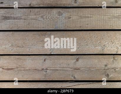 Alte Holzwand aus rohen, unfarbigen Brettern. Fototextur im frontalen, flachen Hintergrund Stockfoto