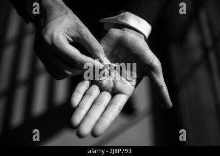 Zwei Eheringe in den Händen des Bräutigams. Stockfoto