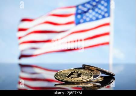 Bitcoin Gold- und ethereum-Silbermünzen vor der us-amerikanischen Flagge auf dem Hintergrund. Virtuelles Kryptowährungskonzept. Kryptowährung. Stockfoto