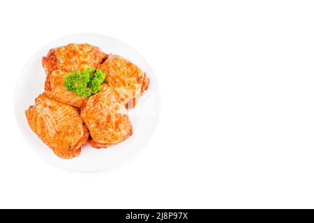 Hähnchenschenkel mariniert in roter Soße auf einem weißen Teller, auf weißem Hintergrund, Banner.Convenience Food, schnelle Koch, halbgekochtes Essen. Stockfoto