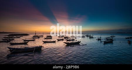 Sonnenuntergang in der Bucht von Jimbaran auf Bali mit Fischerbooten Stockfoto