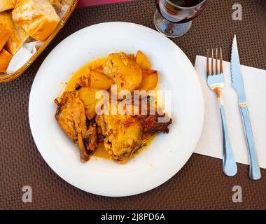 Soße gebackene Hähnchenstücke mit Kartoffeln serviert Stockfoto